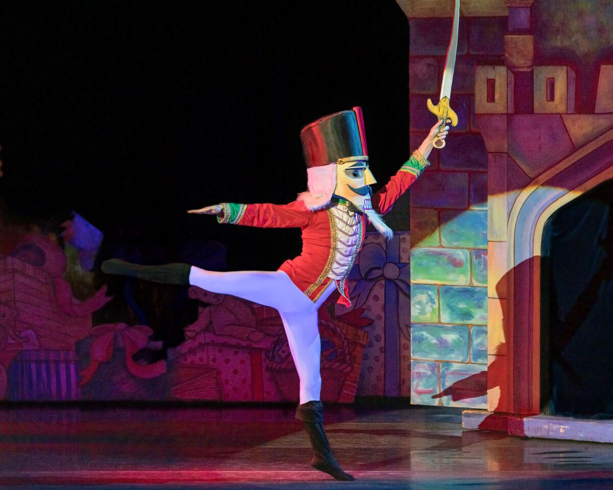 A ballet dancer dressed as a nutcracker raises a sword