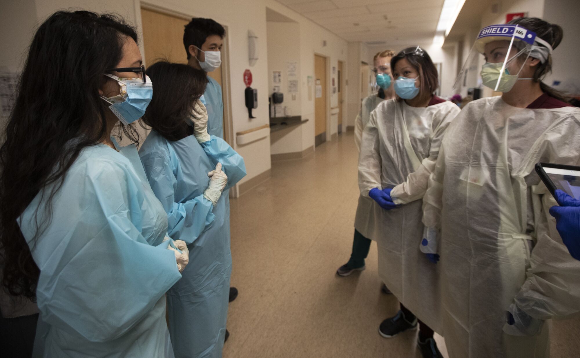 The Harris family consults with nurses in the COVID unit at Providence Holy Cross Medical Center.