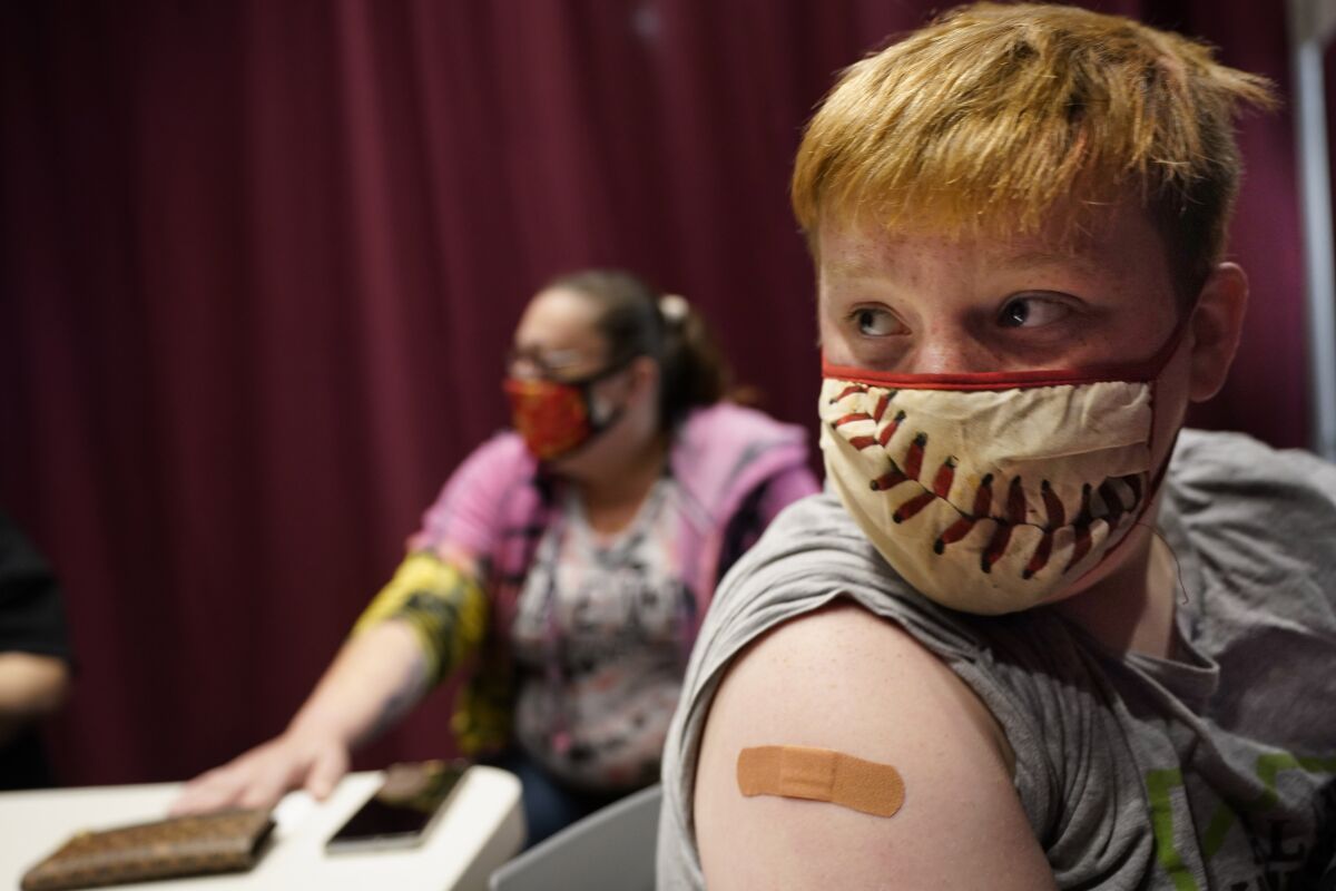Jacob Conary, 15, listens to advice from a medical assistant after receiving his first shot of the COVID-19 vaccination, Wednesday, May 12, 2021, in Auburn, Maine. Vaccination clinics in Maine recently opened up to 12 to 15-year-olds. (AP Photo/Robert F. Bukaty)