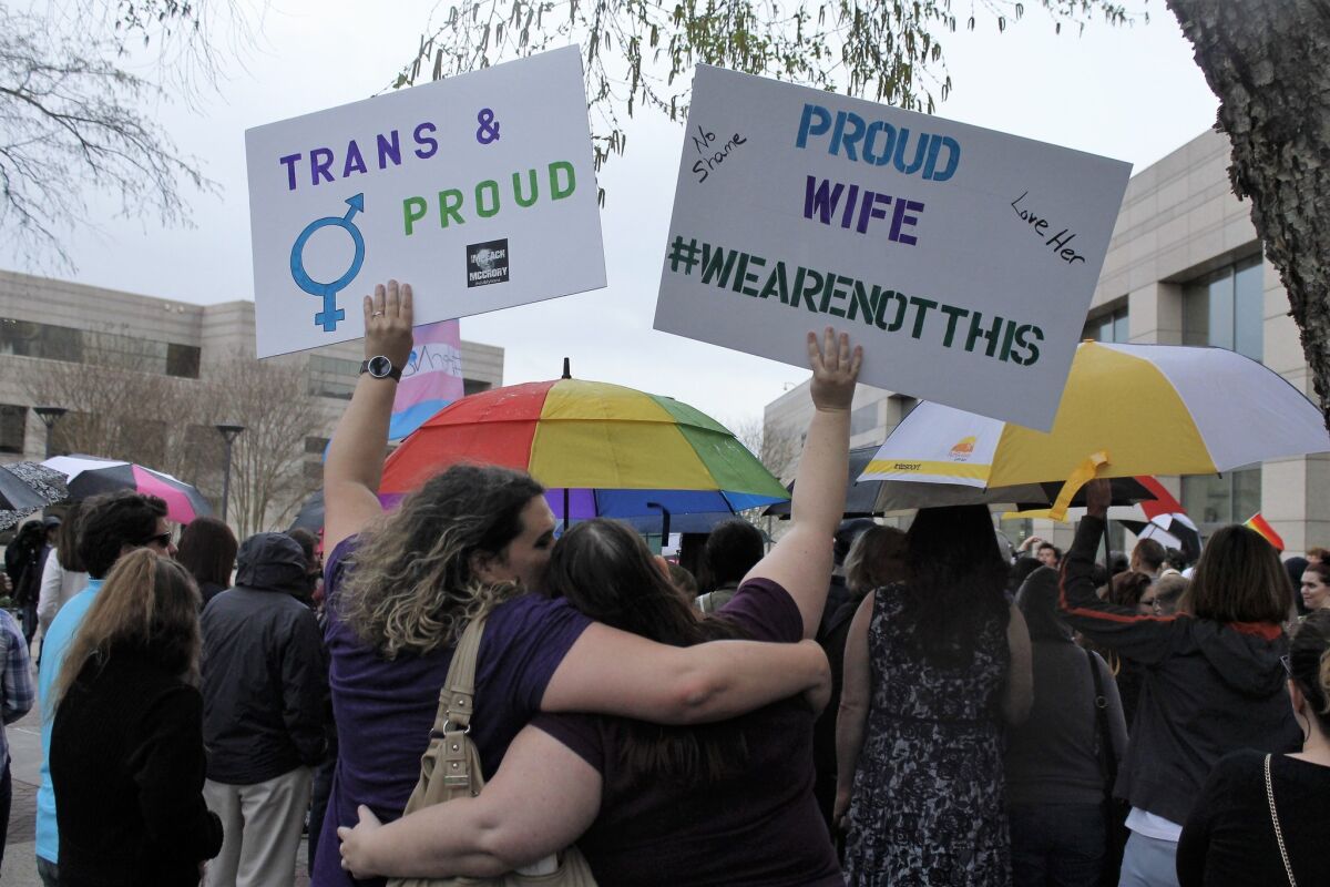 During a rally in Charlotte, N.C., in March, two protesters hold signs against the passage of legislation in the state that limits bathroom options for transgender people.