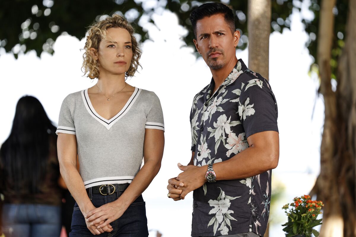 A woman in a shirt and jeans, left, and a man in a Hawaiin shirt