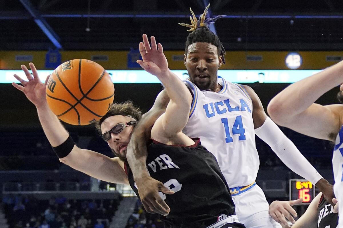 Denver guard Marko Lukic, left, and UCLA forward Kenneth Nwuba go after a rebound.