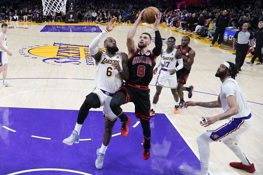 Chicago Bulls guard Zach LaVine (8) drives to the basket between Los Angeles Lakers forward LeBron James, left, and forward Anthony Davis during the second half of an NBA basketball game, Sunday, March 26, 2023, in Los Angeles. (AP Photo/Marcio Jose Sanchez)