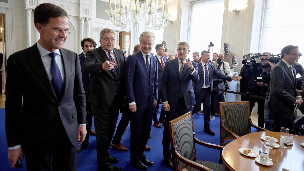 Dutch Prime Minister Mark Rutte, left, and Geert Wilders, center, of the far-right Freedom Party arrive for a meeting between main party leaders and the chairman of the Senate in The Hague one day after the general elections.