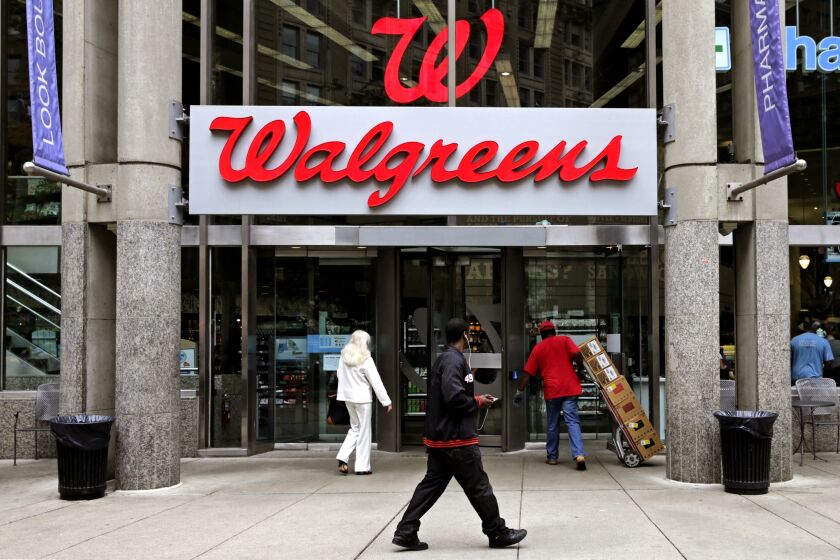 FILE - In this June 4, 2014, file photo, people walk in to a Walgreens retail store in Boston. Walgreens slashed its 2019 forecast and missed second-quarter expectations with a performance that sent its shares plunging Tuesday, April 2, 2019 and knocked down the Dow Jones industrial average. The nation’s largest drugstore chain said it now expects adjusted earnings per share to be roughly flat this year after confirming as recently as late December a forecast for growth of 7% to 12%. (AP Photo/Charles Krupa, File)