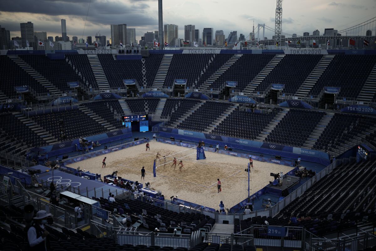 Players compete in a volleyball match in a nearly empty venue.