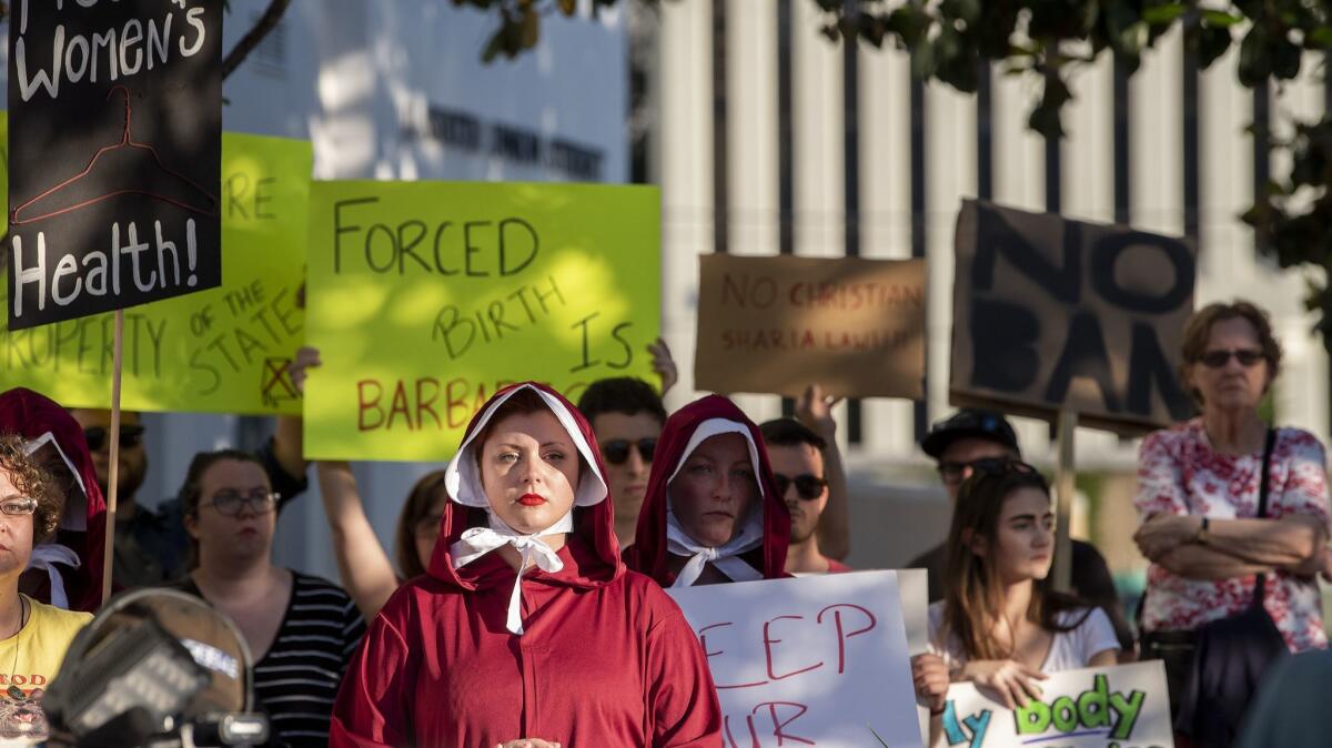Margeaux Hartline, dressed as a handmaid, joins a protest against HB 314, the near-total ban on abortion, outside of the Alabama State House in Montgomery on Tuesday.