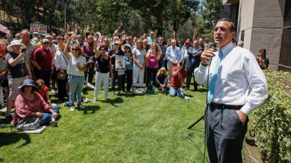 Rep. Darrell Issa (R-Vista) speaks to a crowd of protesters outside his district office.