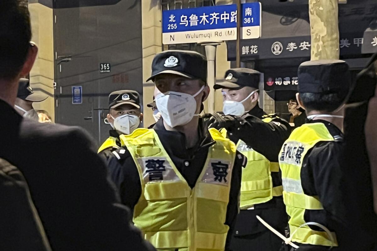 Chinese police officers block access to a site where protesters had gathered on Sunday in Shanghai.