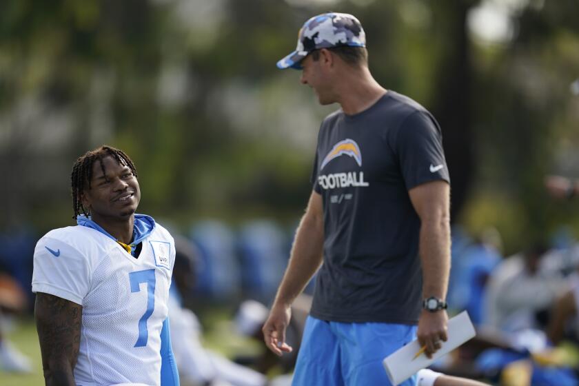 Los Angeles Chargers tight end Gerald Everett, left, greets head coach Brandon Staley at the NFL football team's practice facility in Costa Mesa, Calif. Monday, Aug. 1, 2022. (AP Photo/Ashley Landis)