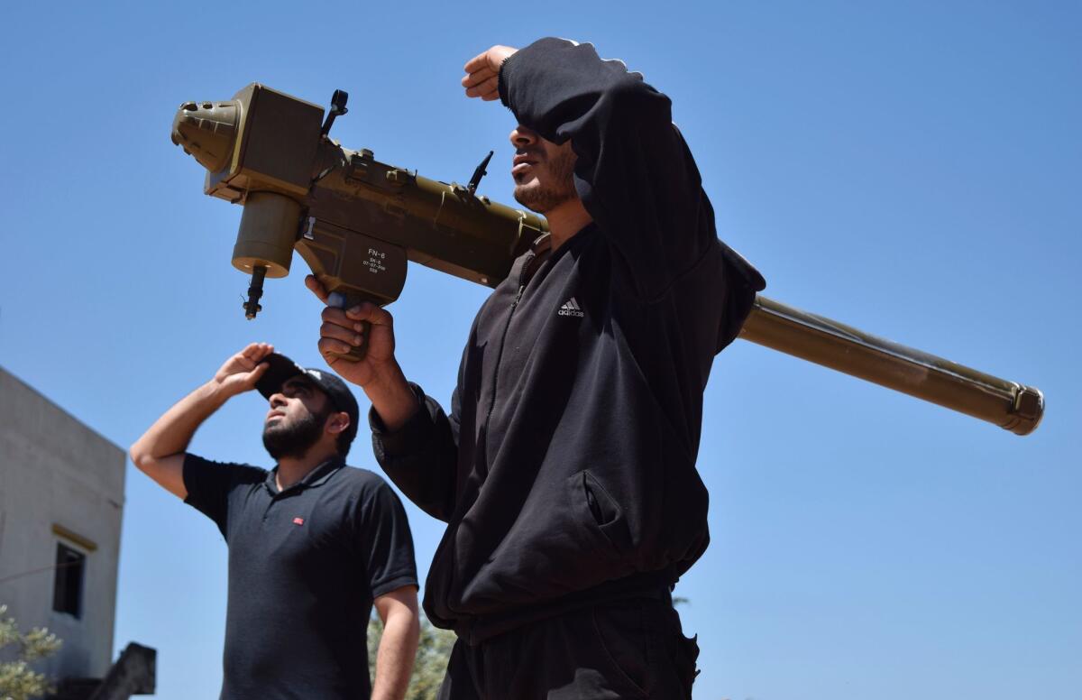 Rebel fighters monitor the sky holding an FN-6 man-portable air-defense system, or MANPAD, in the Syrian village of Teir Maalah, on the northern outskirts of Homs, on April 20, 2016.