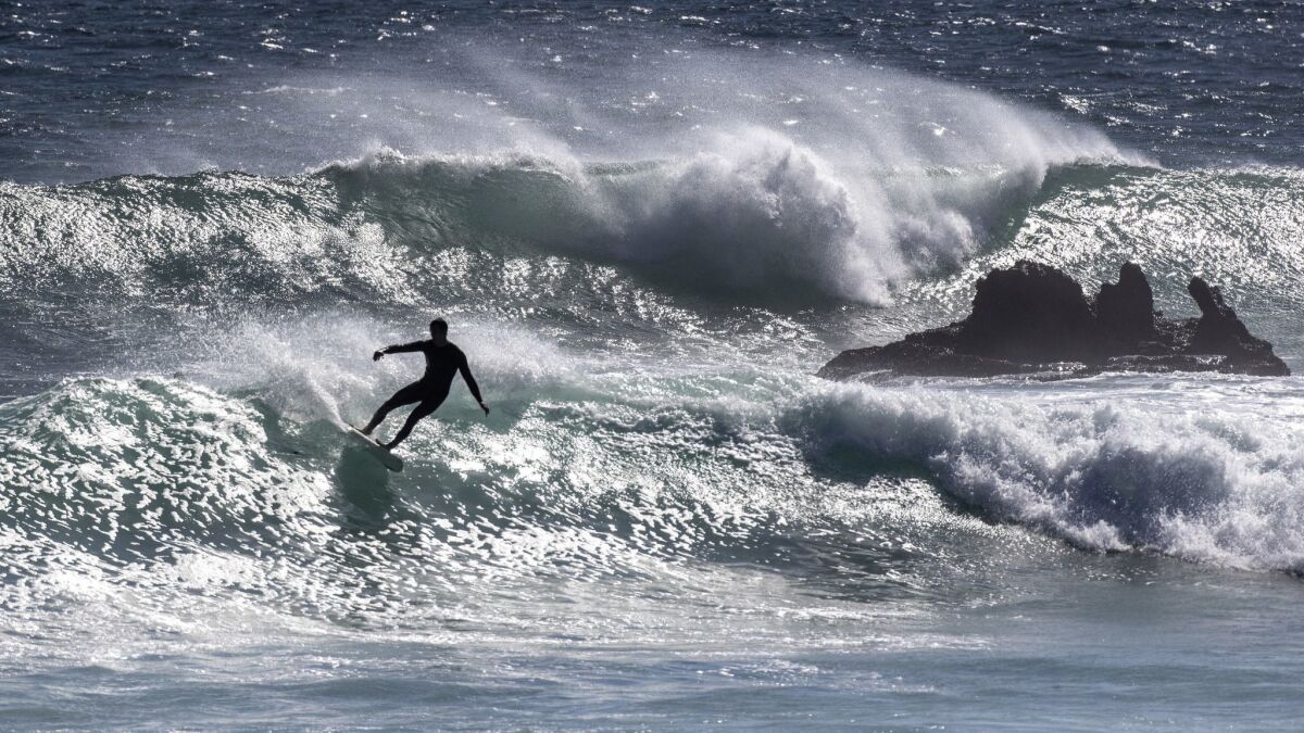 Surfers take advantage of 5- to 7-foot waves at Leo Carrillo State Beach in Malibu on Monday.