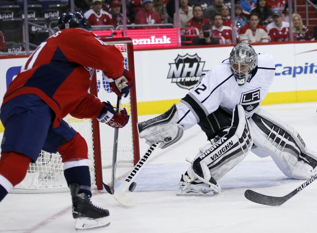 Capitals center Mike Richards, left, reaches for the puck at the same time as Kings goalie Jonathan Quick in the first period.