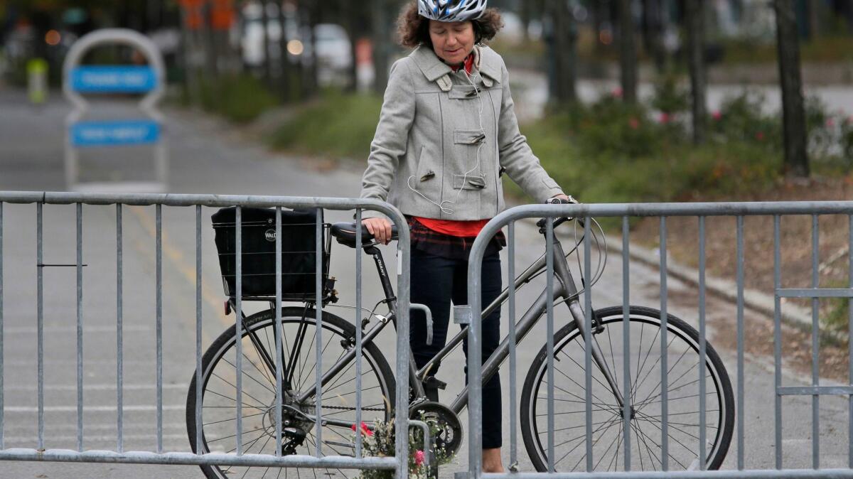 Celia Imrey pauses after laying flowers at the edge of a Manhattan bike path where eight people were killed on Tuesday.