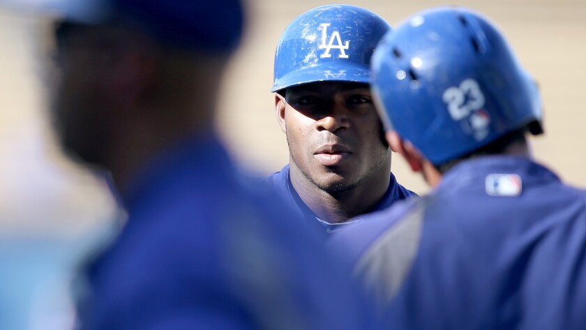 Dodgers center fielder Yasiel Puig talks with teammates during batting practice before a game against the San Diego Padres on Aug. 21.