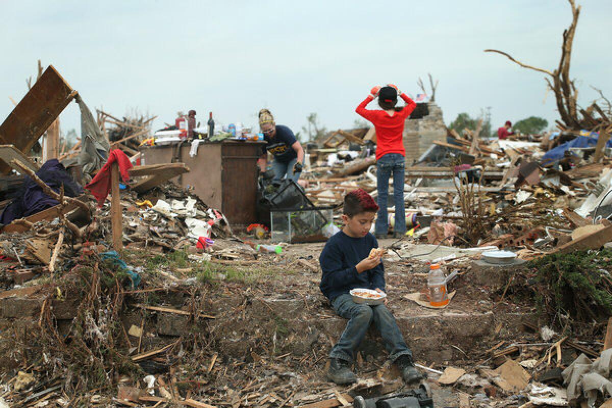 Ty Langoc takes a lunch break while helping his parents recover belongings from their house, which was destroyed by the tornado in Moore, Okla.
