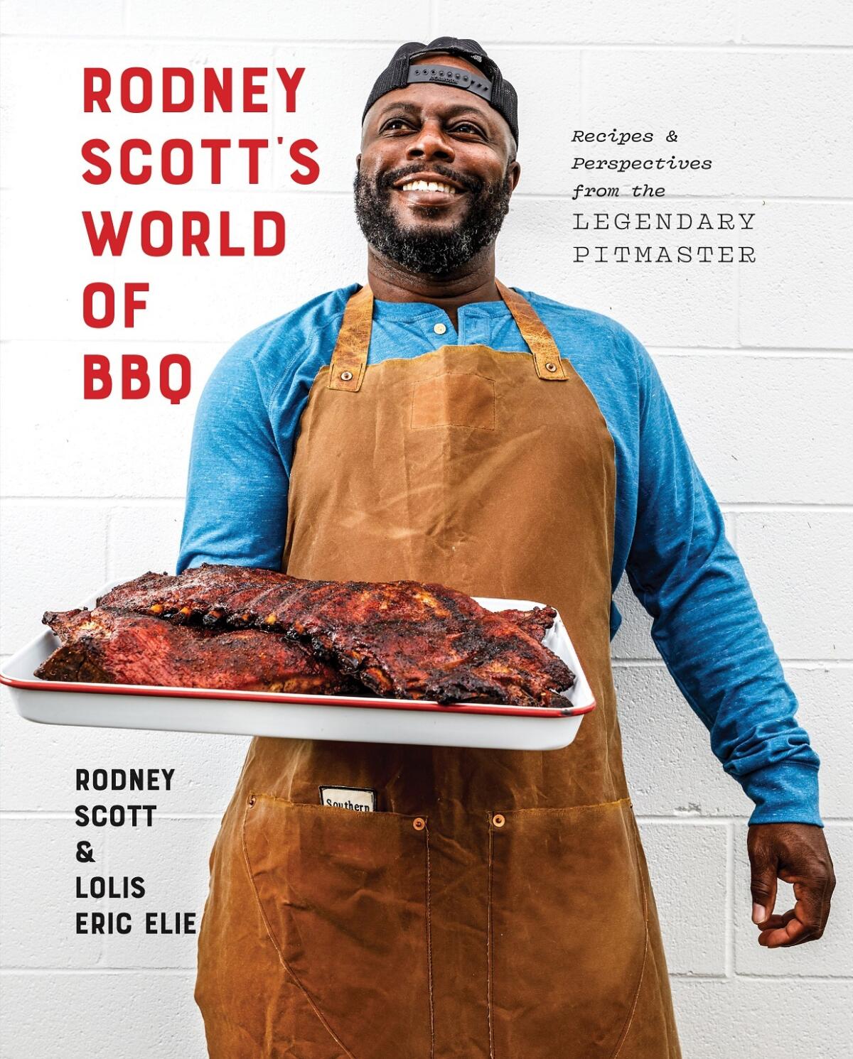 The book cover of "Rodney Scott's World of BBQ" by Rodney Scott and Lolis Eric Elie pictures Scott holding a rack of ribs