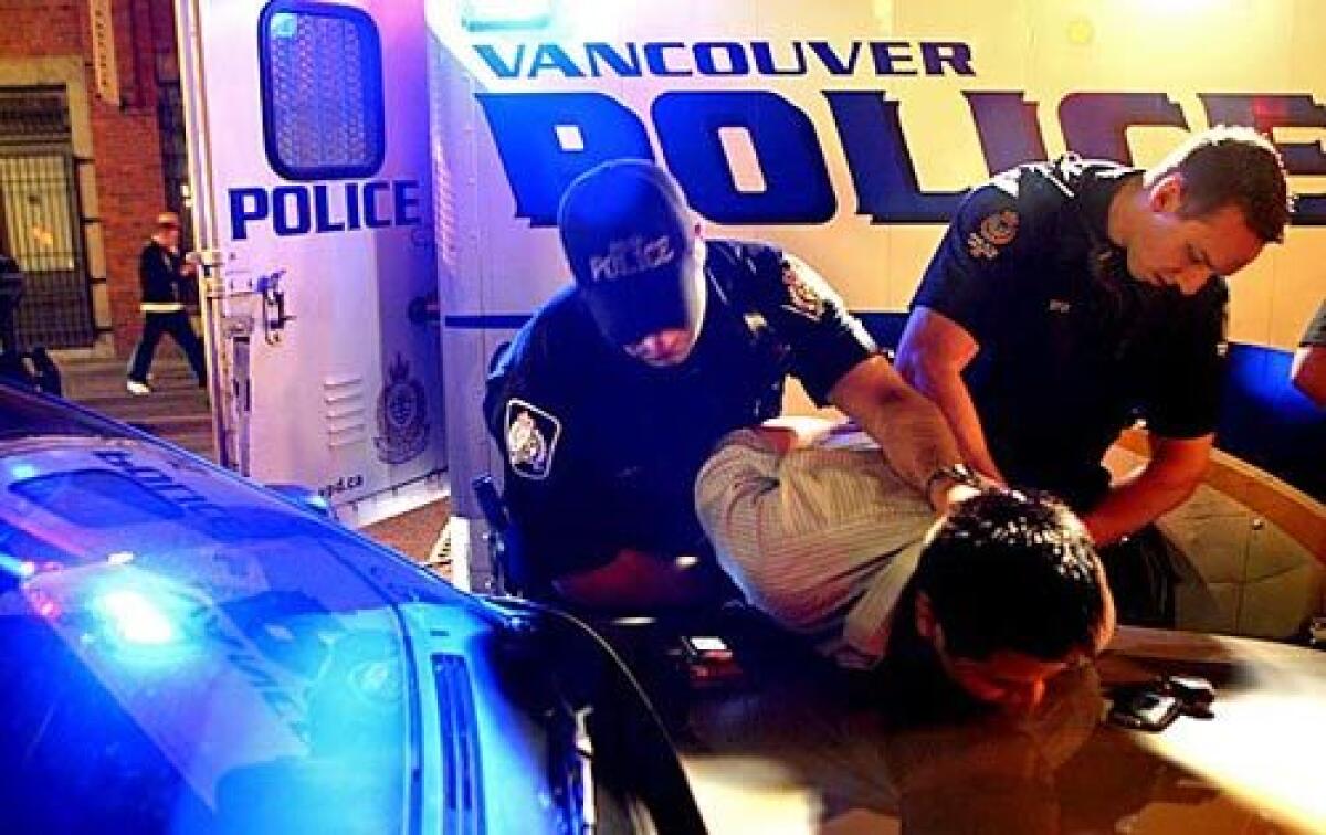 Vancouver police on the anti-gang task force handcuff a patron outside a club in the city's Gastown district. Authorities trace the violence to the recent government crackdown on cocaine traffickers in Mexico, which has squeezed profit margins for cocaine north of the U.S. border. More photos >>>