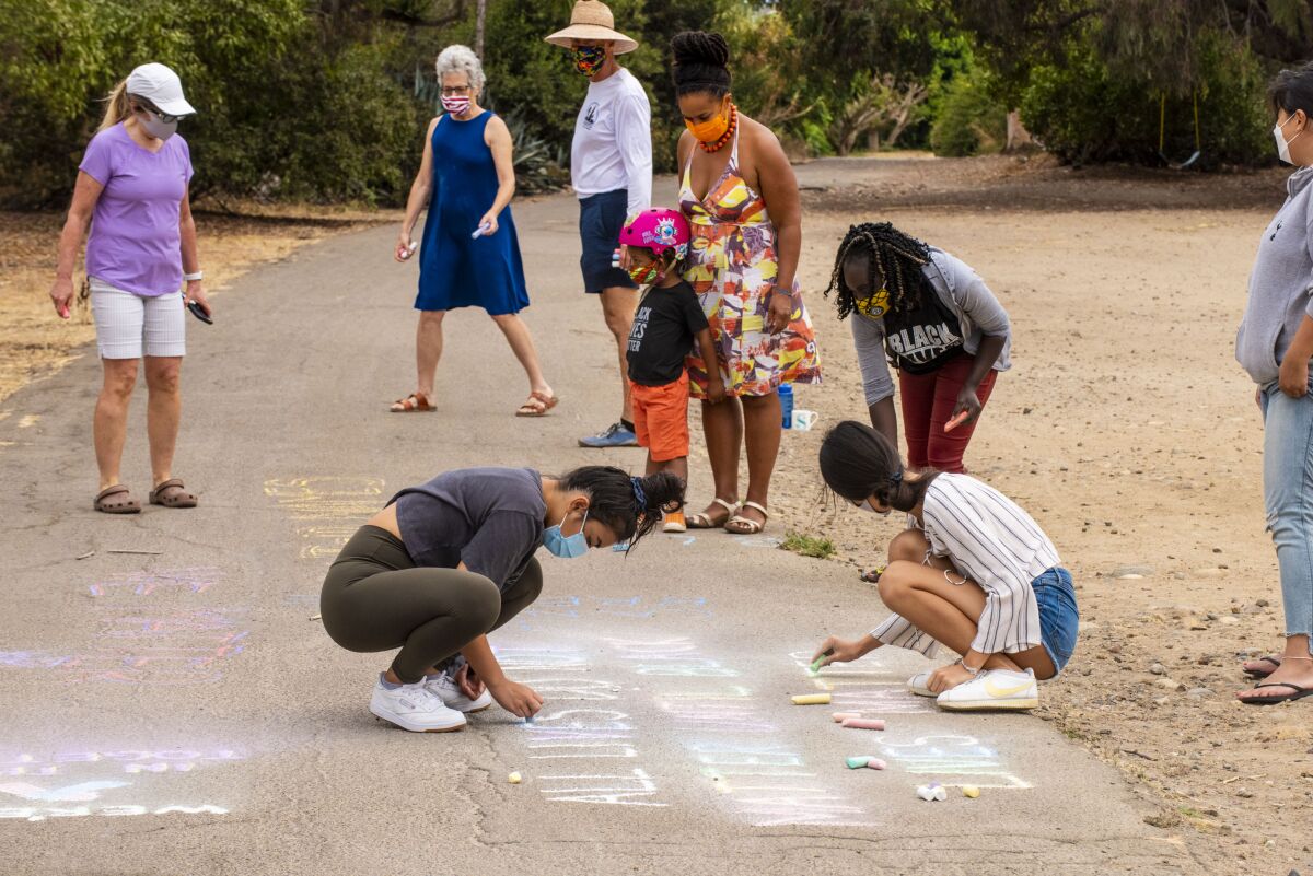 Participants in a Labor Day chalk-in draw on the La Jolla Bike Path in a show of support for the Black Lives Matter movement.