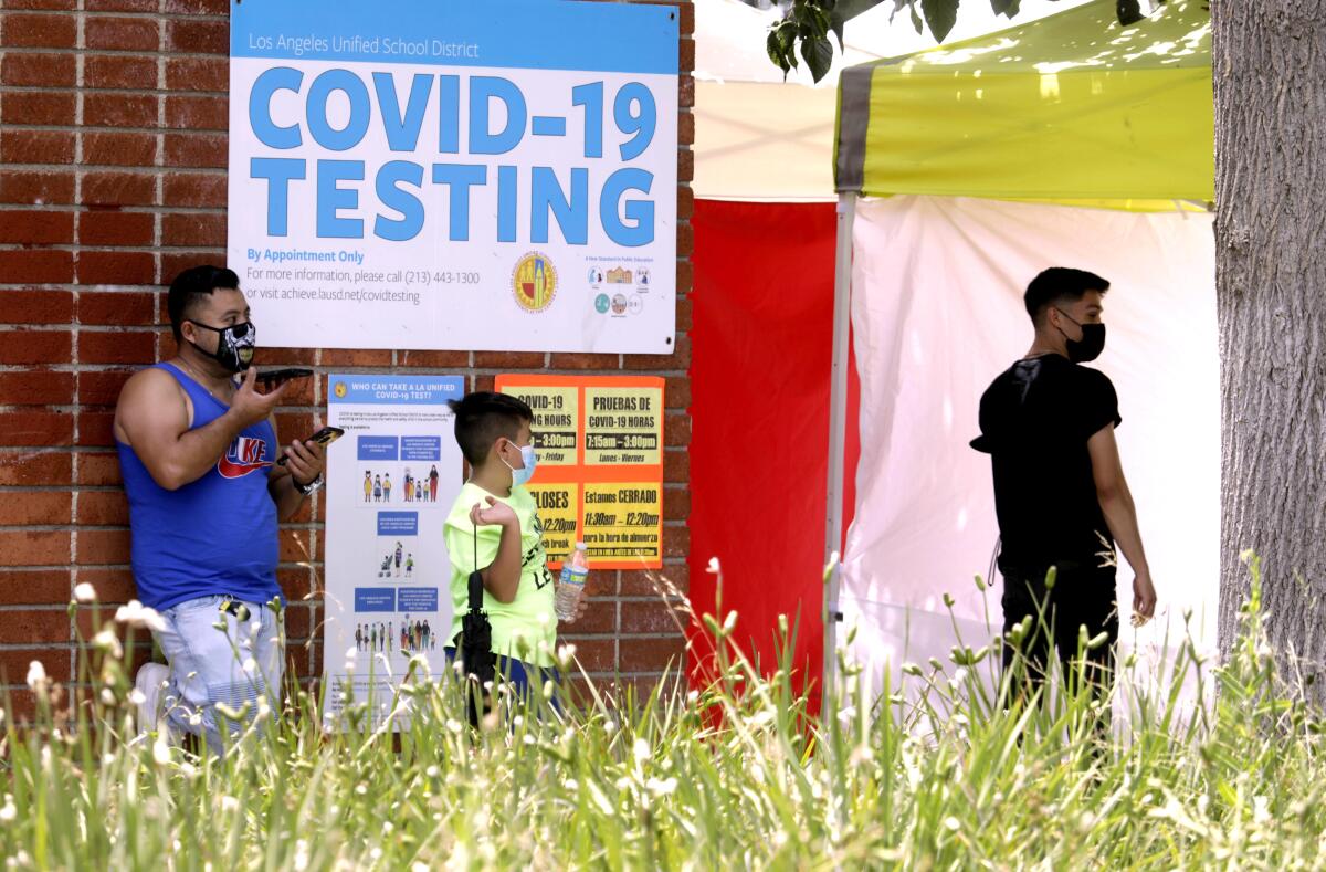 A father waits with his son to be tested for the coronavirus outside Northridge Middle School.