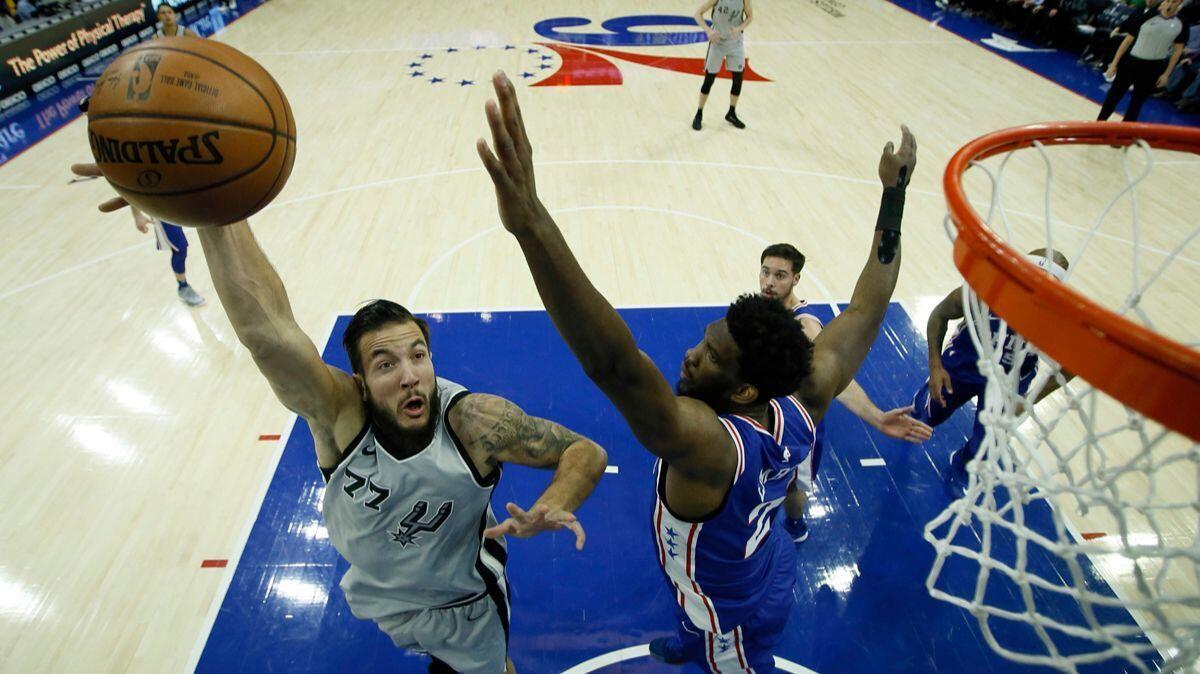 San Antonio Spurs' Joffrey Lauvergne (77) goes up for a shot past Philadelphia 76ers' Joel Embiid during the first half on Wednesday.