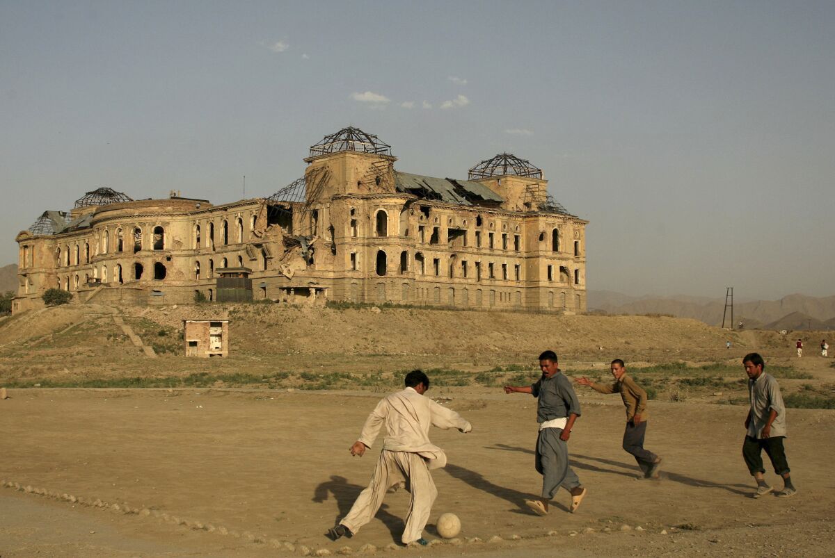 FILE -- In this July 1, 2008 file photo, Afghans play football in front of the destroyed Darul Aman Palace in the western part of Kabul, Afghanistan. The Taliban fighters who rolled into Afghanistan's capital and other cities in recent days appear awestruck by the towering apartment blocks, modern office buildings and shopping malls. When the Taliban last seized power, in 1996, the country had been ravaged by civil war and the capital was in ruins. (AP Photo/Farzana Wahidy, File)