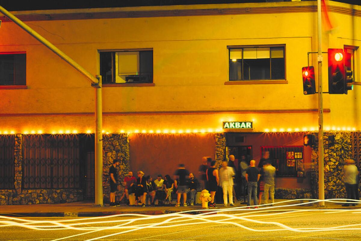 Before the pandemic, people gather outside the entrance to a nightclub.
