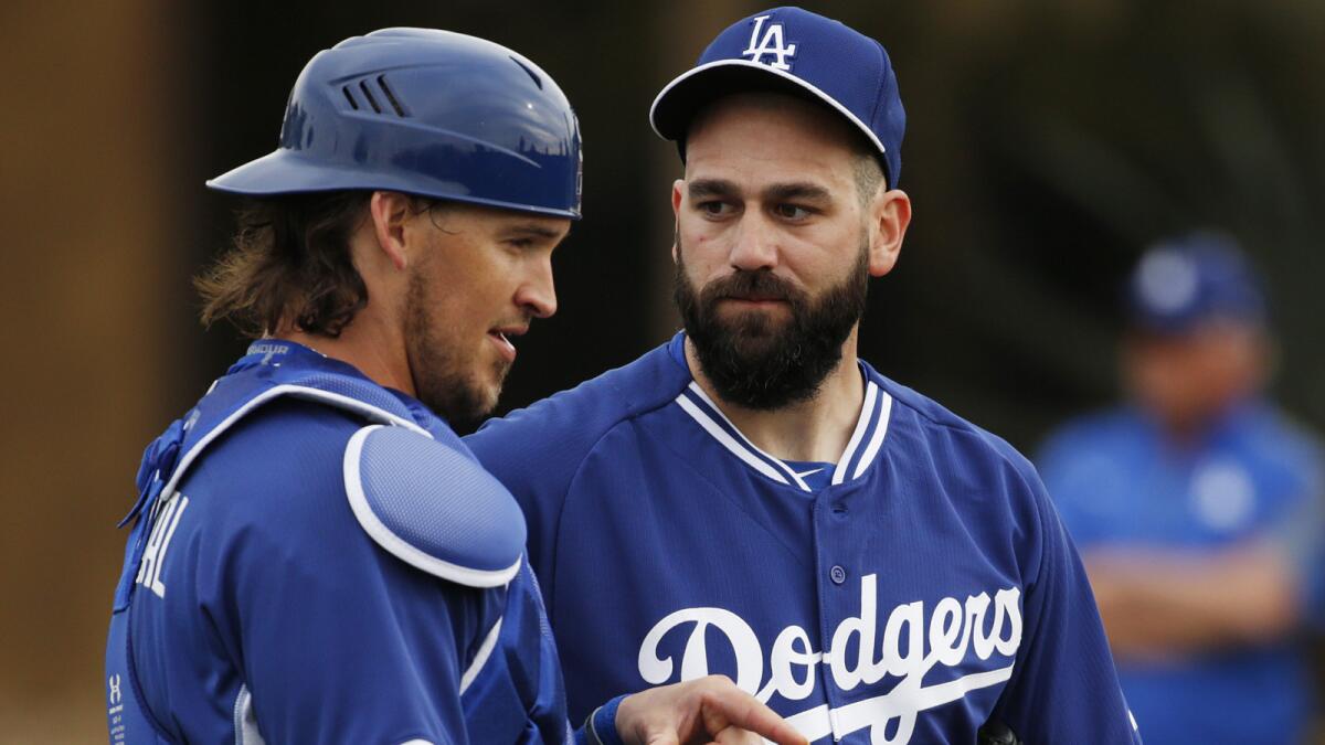 Los Angeles Dodgers' Yasmani Grandal, left, speaks with Chris Hatcher during the team's first pitchers and catchers workout on Feb. 20, 2015, in Phoenix.