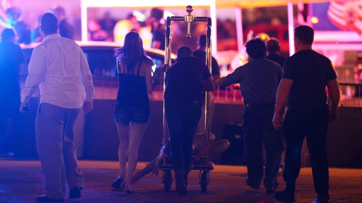 A wounded woman is moved outside the Tropicana during an active shooter situation on the Las Vegas Strip on Oct. 1..