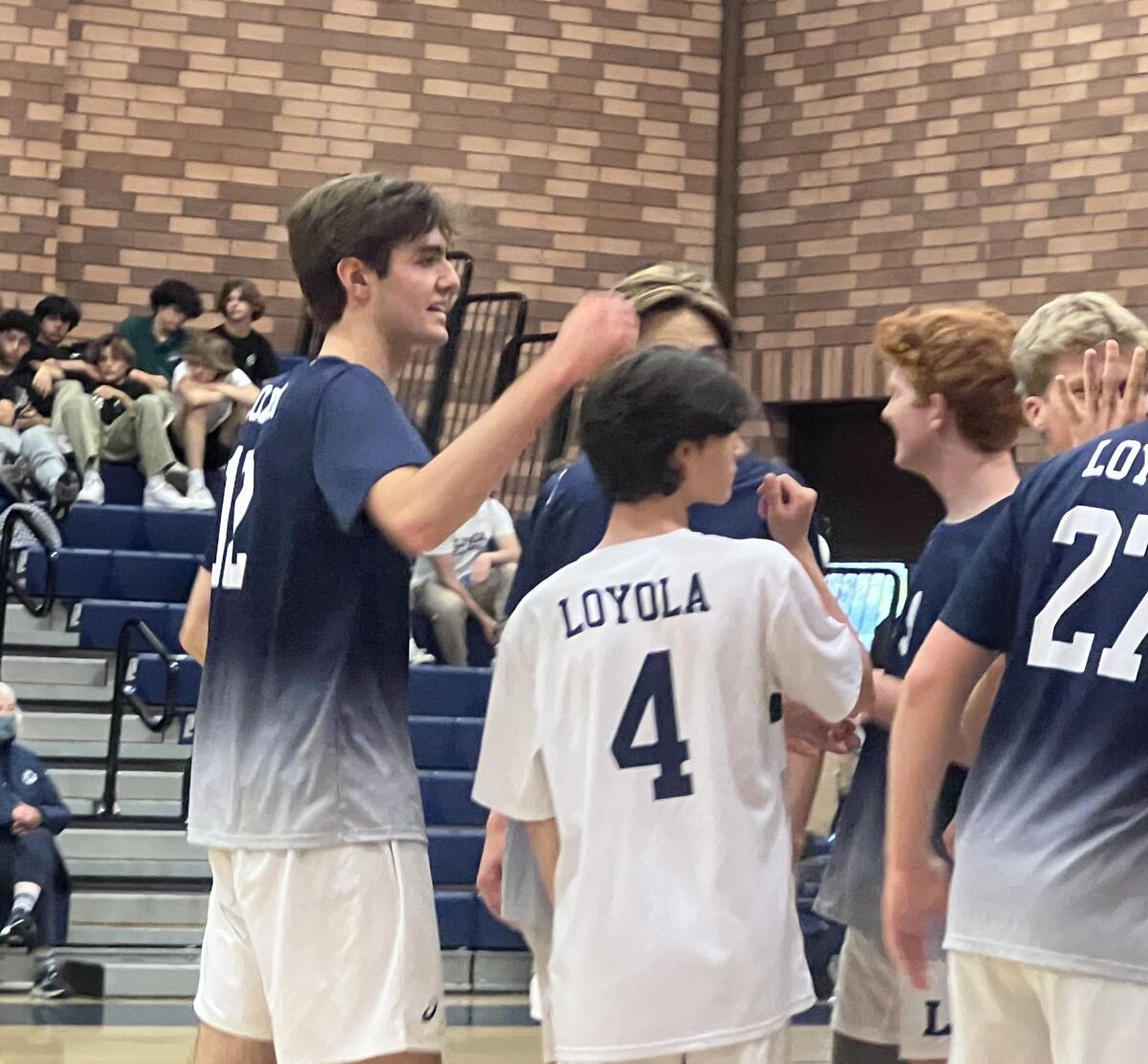 Sean Kelly, left, celebrates with his teammates after getting 21 kills for Loyola in its volleyball playoff win over Edison.