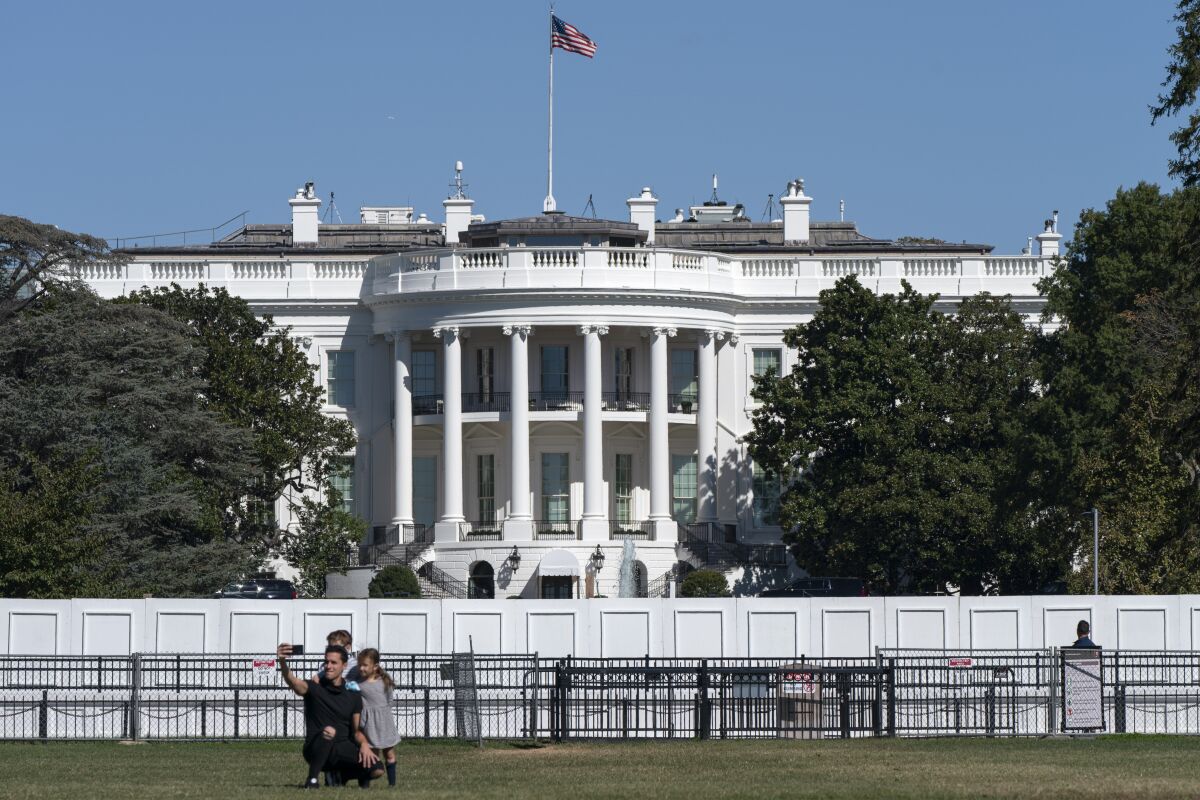 A family takes group portrait, Thursday, Oct. 8, 2020, outside of the White House in Washington. (AP Photo/Jacquelyn Martin)