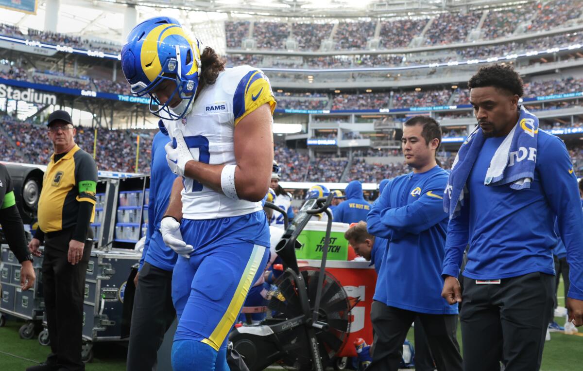 Rams receiver Luka Nacua walks off the field holding his side after suffering an injury against the Browns.