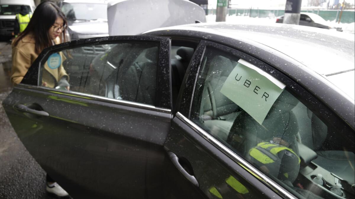 A woman gets in an Uber car at LaGuardia Airport in New York in 2017.