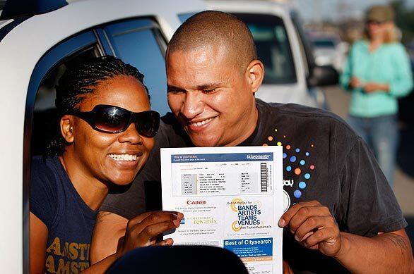 Michael Jackson fans Shaneese and Bob Lewis, of Palm Springs, show off the vouchers for tickets to the Jackson memorial that they won in an online lottery. The couple were among those lining up outside Dodger Stadium to get their tickets and wristbands to the Tuesday event. "I feel very lucky," said Bob Lewis, who won the tickets. "I learned to dance watching Michael Jackson."