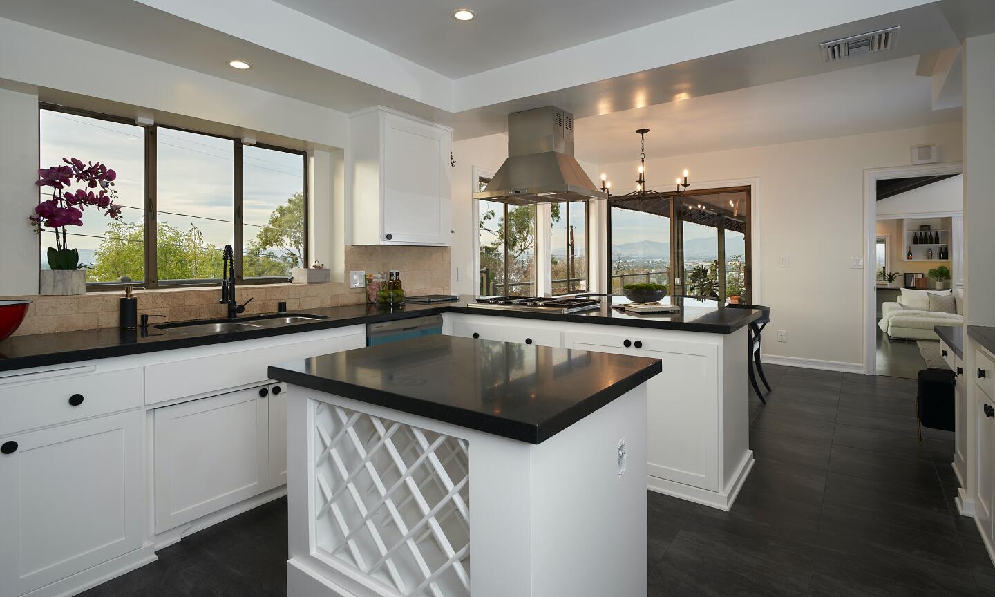 The kitchen has an island with built-in wine rack and recessed ceiling.