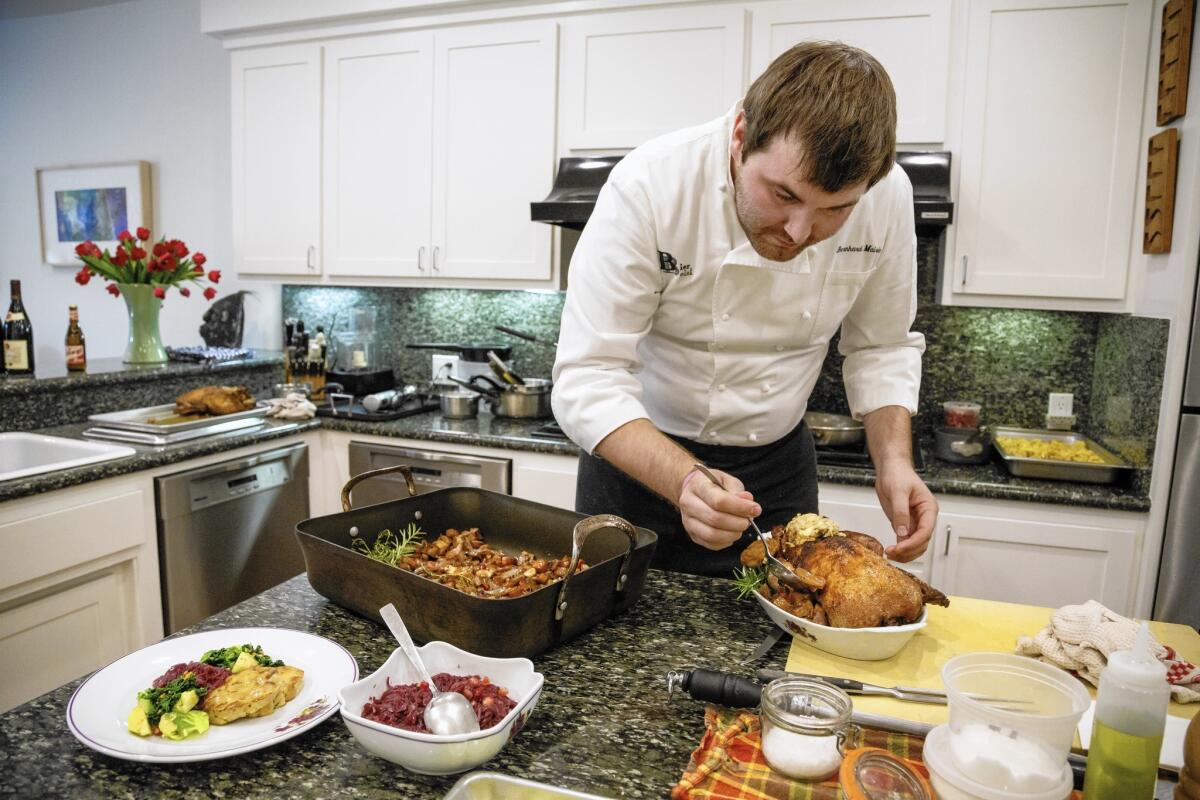 Chef Bernhard Mairinger prepares roast duck, a traditional Christmas Eve dinner dish in Austria, at the home of friends.