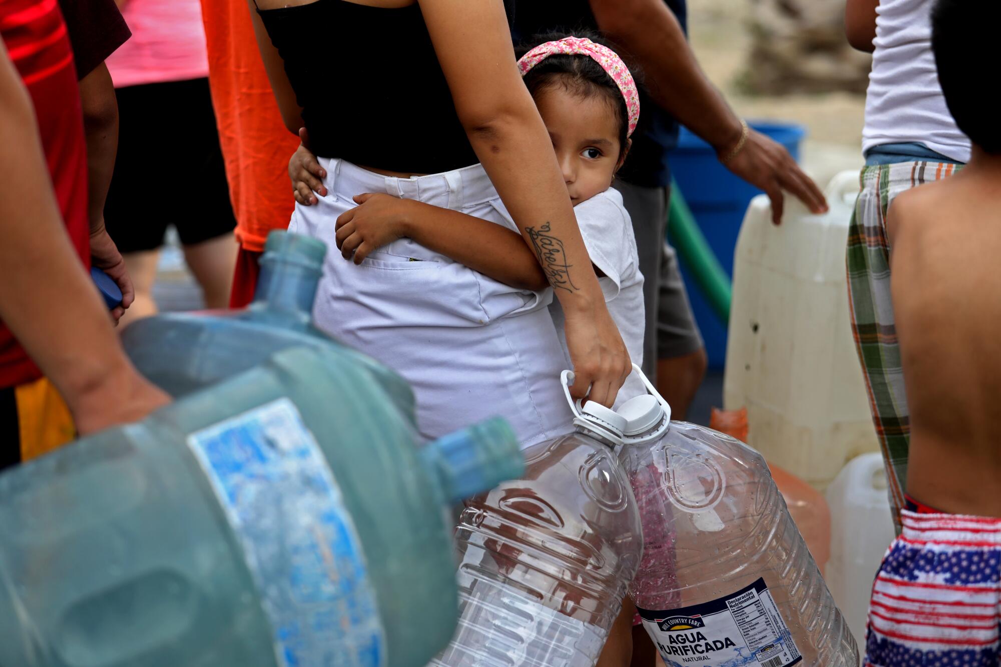 A young girl waits in line for non-potable water