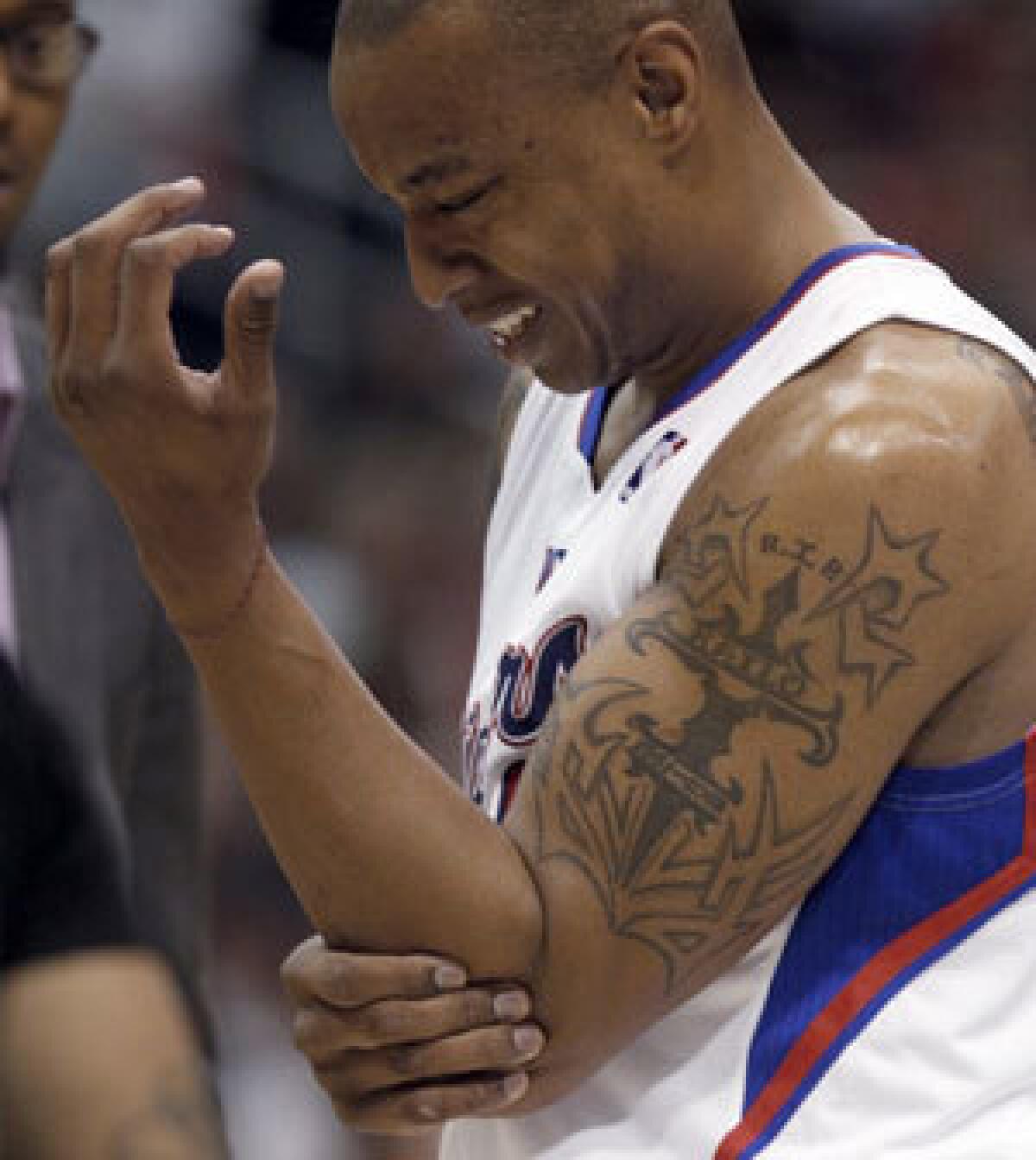 Caron Butler grabs his elbow after injuring it in a game against the Detroit Pistons on Sunday.