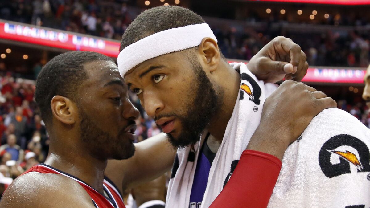 Washington Wizards guard John Wall, left, speaks to Sacramento Kings center DeMarcus Cousins after a game on March 14.