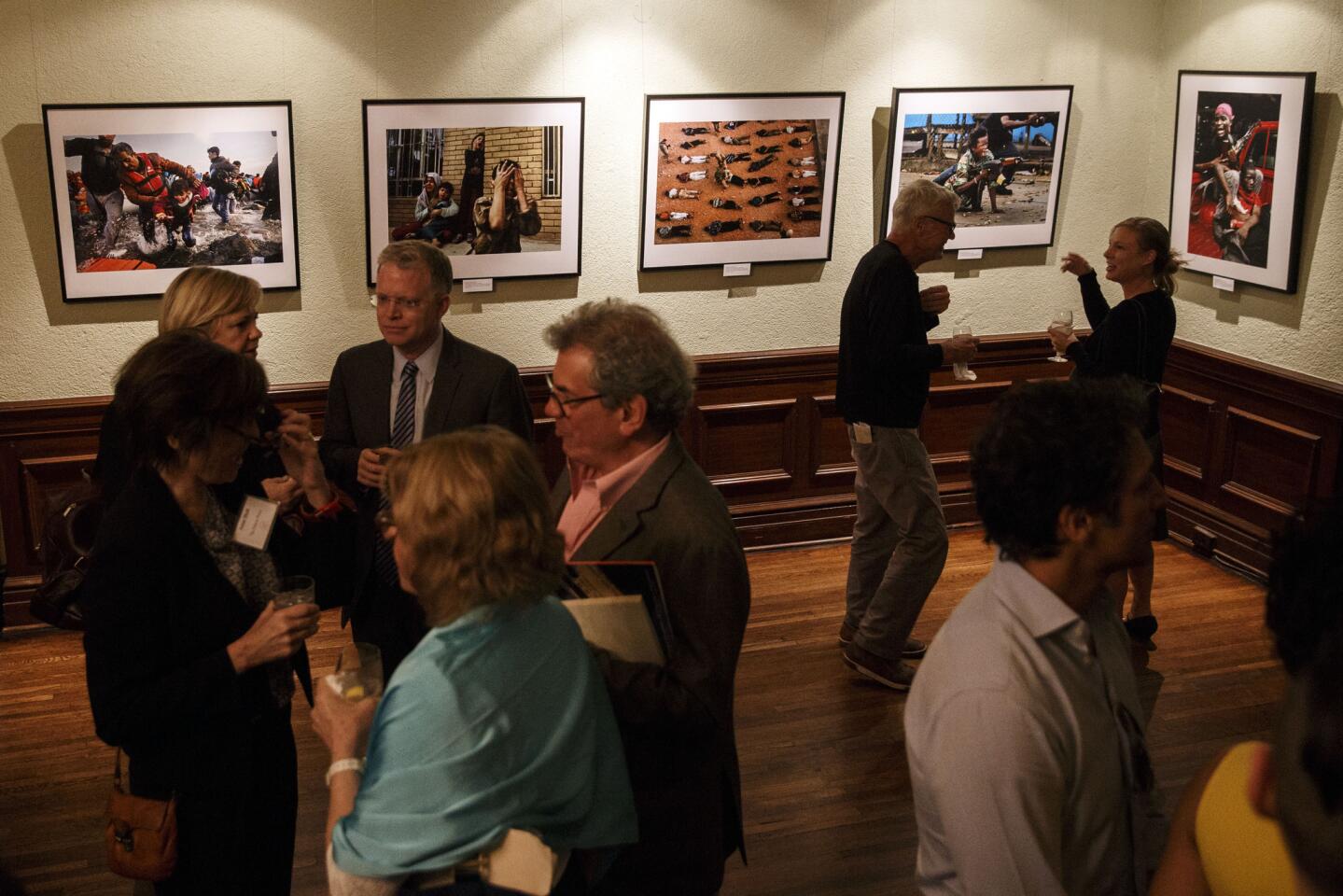 Attendees view Los Angeles Times photojournalist Carolyn Cole's Pulitzer winning work from Liberia during The Pulitzer Centennial Celebration at the Ebell Theatre in Los Angeles.