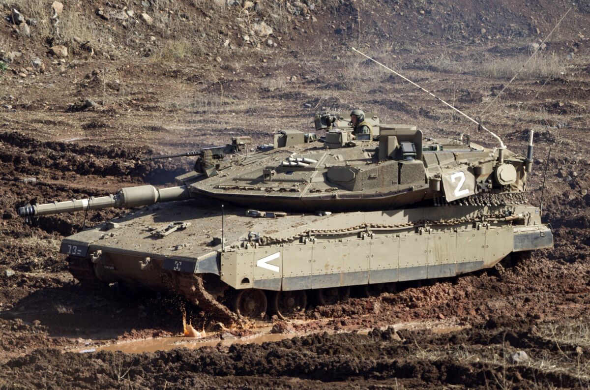 An Israeli tank in a firing position Monday in the Israeli-controlled Golan Heights overlooking the Syrian village of Bariqa. The Israeli military says Syrian mobile artillery was hit after Israel responded to apparently stray mortar fire from its neighbor.
