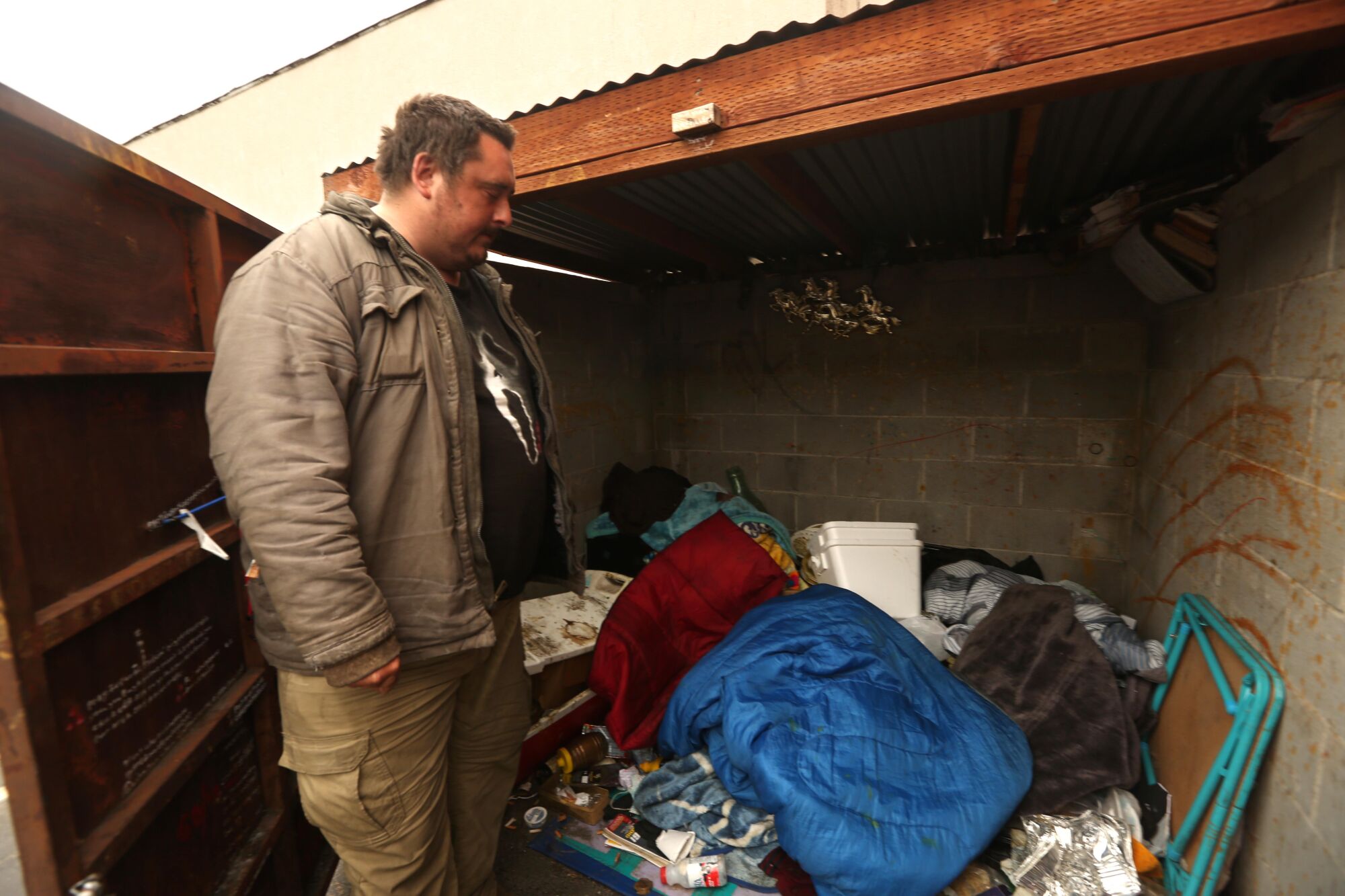 Andrew Truelove stores his two worn sleeping bags in a structure that once housed a garbage dumpster.