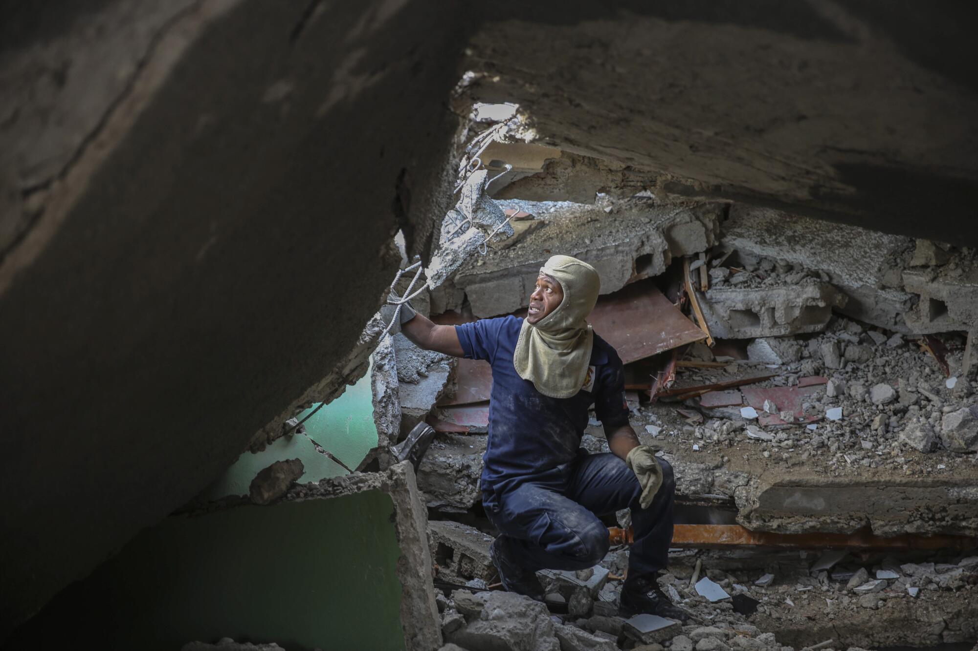 A firefighter searches for survivors inside a damaged building amid debris