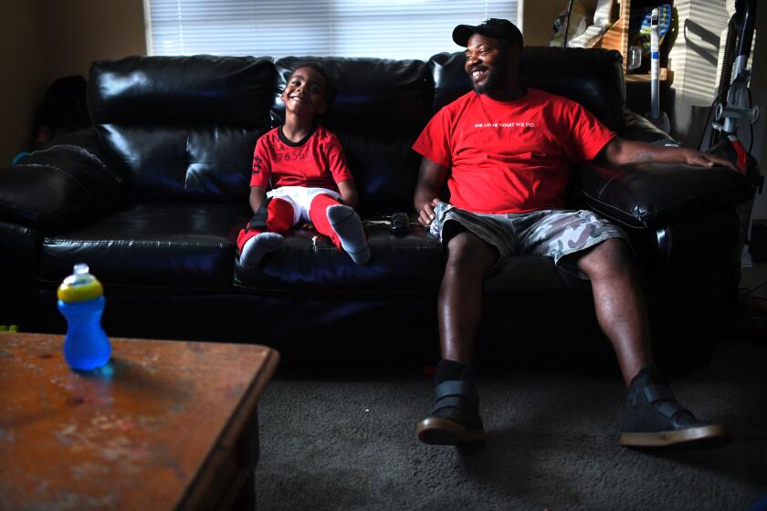 ORLANDO, FLORIDA OCTOBER 23, 2019-Curtis Bryant spends time with his son Curtis Jr. realx and watch tv on the couch at there home in Orlando, Florida. (Wally Skalij/Los Angerles Times)