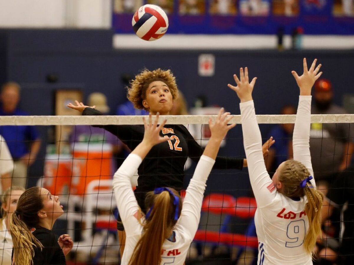 Huntington Beach High's Xolani Hodel (12), seen battling at the net against Los Alamitos during a Surf League match on Sept. 19, has verbally committed to play beach volleyball at Stanford.