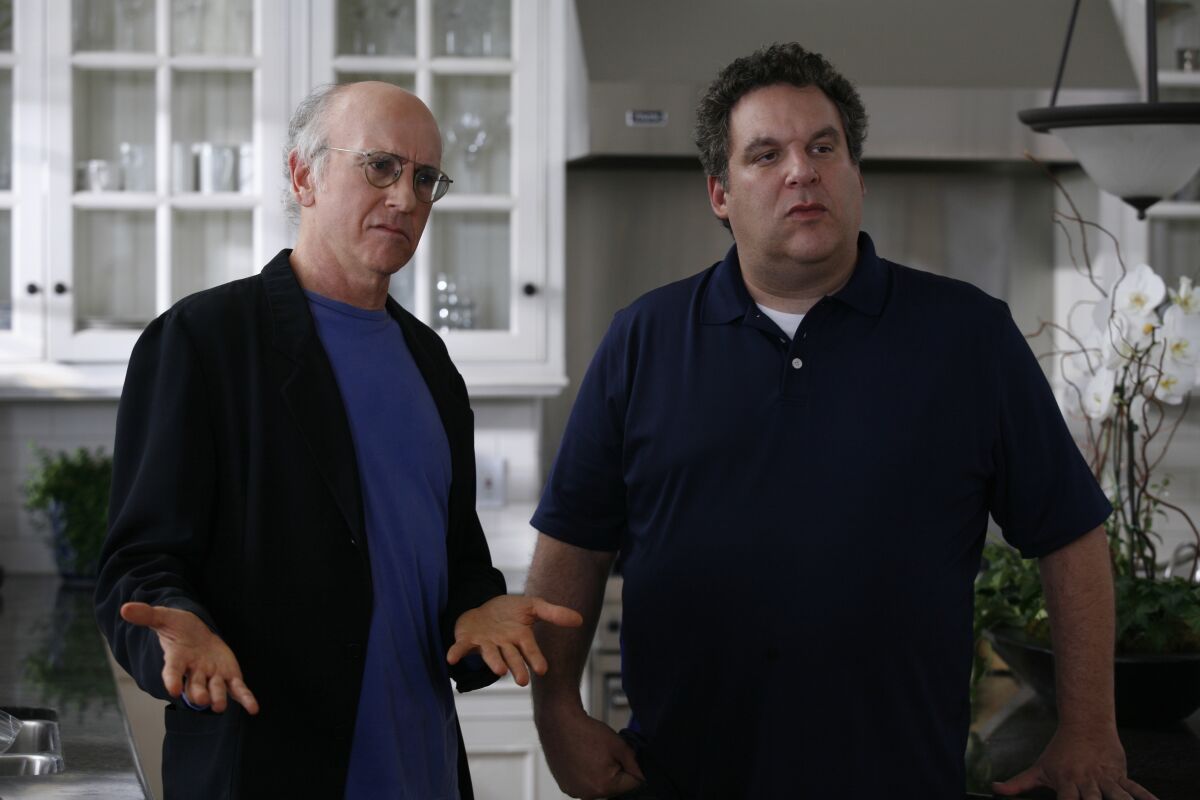Two men standing in a kitchen.