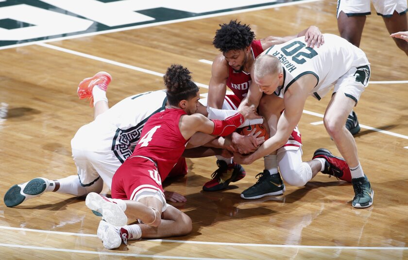 Michigan State's Joshua Langford, left, and Joey Hauser (20) and Indiana's Khristian Lander (4), Jerome Hunter, right rear, and Trey Galloway, center (obscured) vie for the ball during the first half of an NCAA college basketball game, Tuesday, March 2, 2021, in East Lansing, Mich. (AP Photo/Al Goldis)