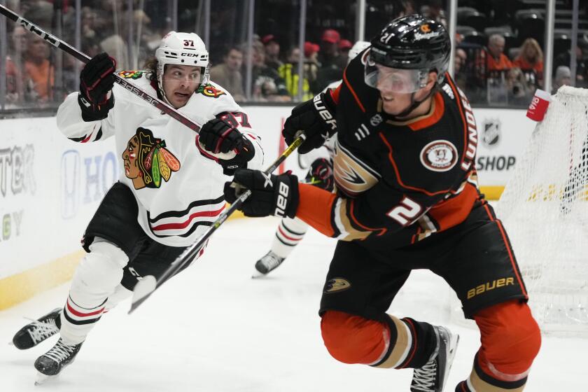 Chicago Blackhawks' David Gust (37) and Anaheim Ducks' Isac Lundestrom (21) chase the puck.