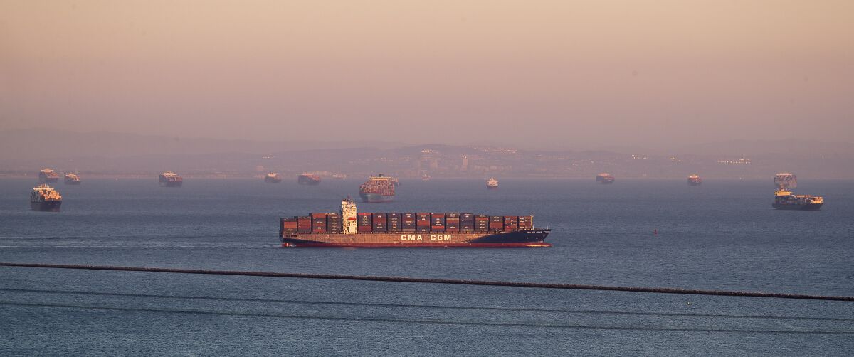 Container ships are seen off the coast under a hazy sky