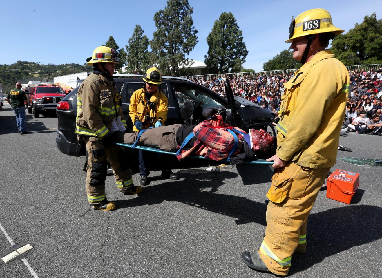 L.A. County firefighters prepare victim of a mock accident, senior student Brandon Grandalski, during the Every 15 Minutes staged event in front of La Canada High School, in La Canada Flintridge on Thursday, April 11, 2019.